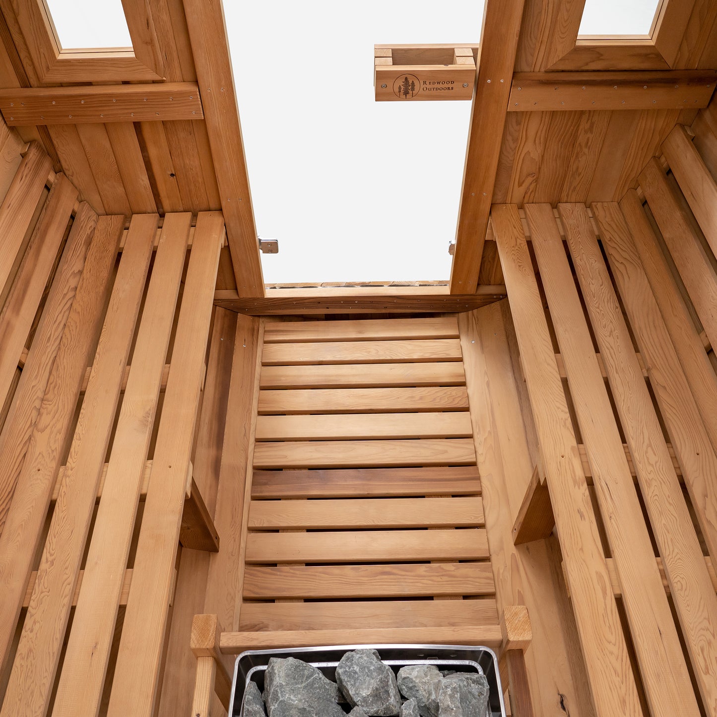 Redwood Outdoors Vista 6 person outdoor sauna, made of hemlock wood with large rear window, heater with guard and two benches on both sides.