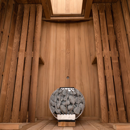 Redwood Outdoors 6 person Barrel Outdoor Sauna with porch made of hemlock, inside view from the front, two benches on either side with a heater in the rear.