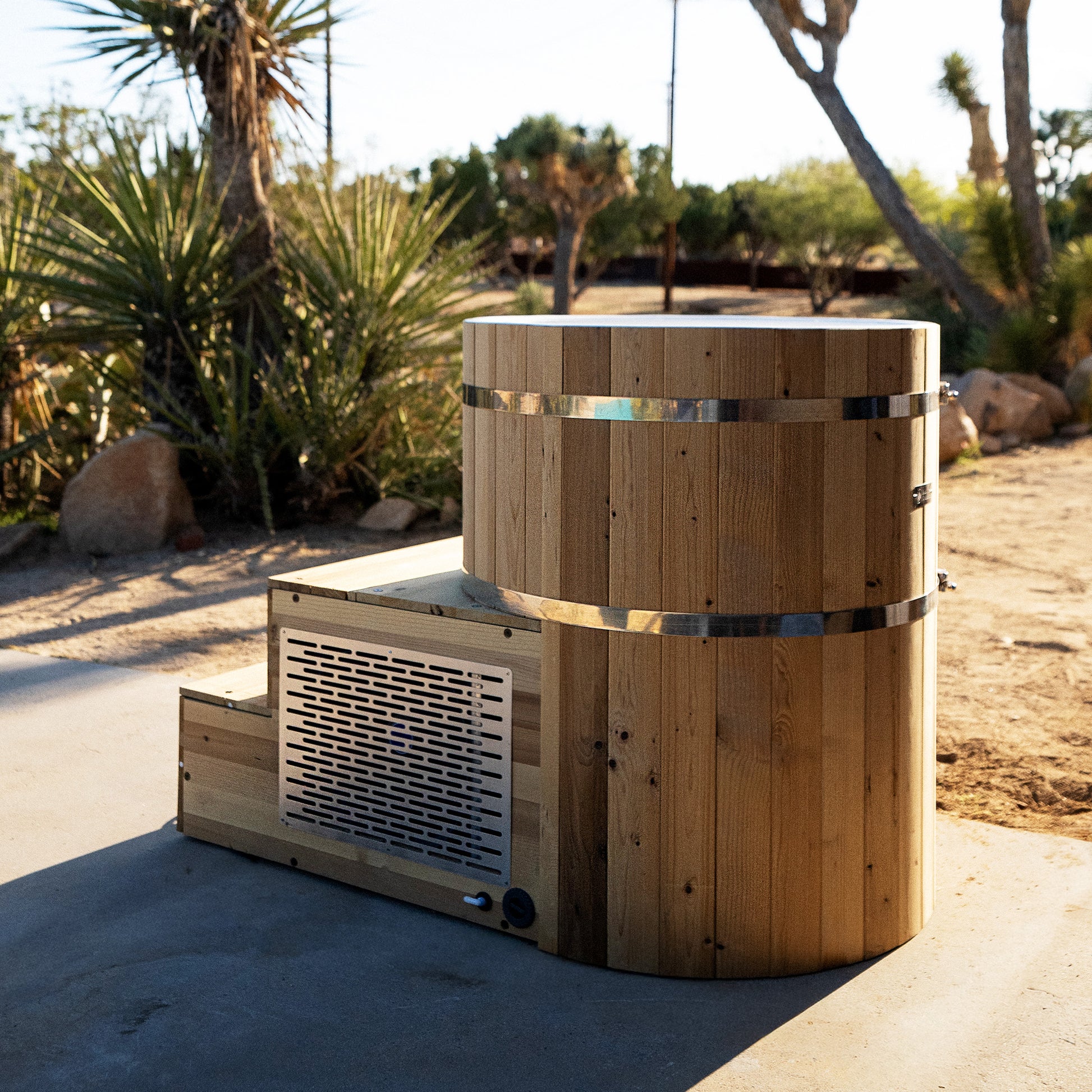 Redwood Outdoors Alaskan All-In_One Cold Plunge Tub made of heat treated wood exterior view with the lid off on a patio.