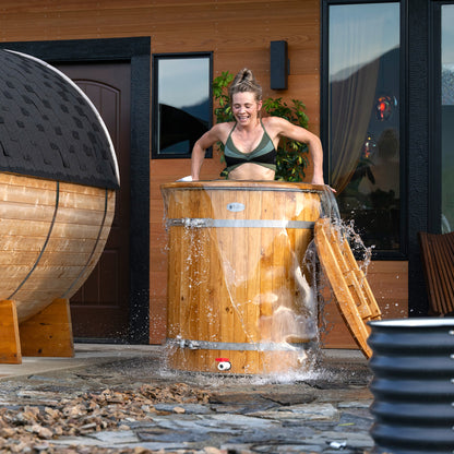 Redwood Outdoors Alaskan Cold Plunge Tub made of heat treated wood exterior with a person plunging in the tub with water.