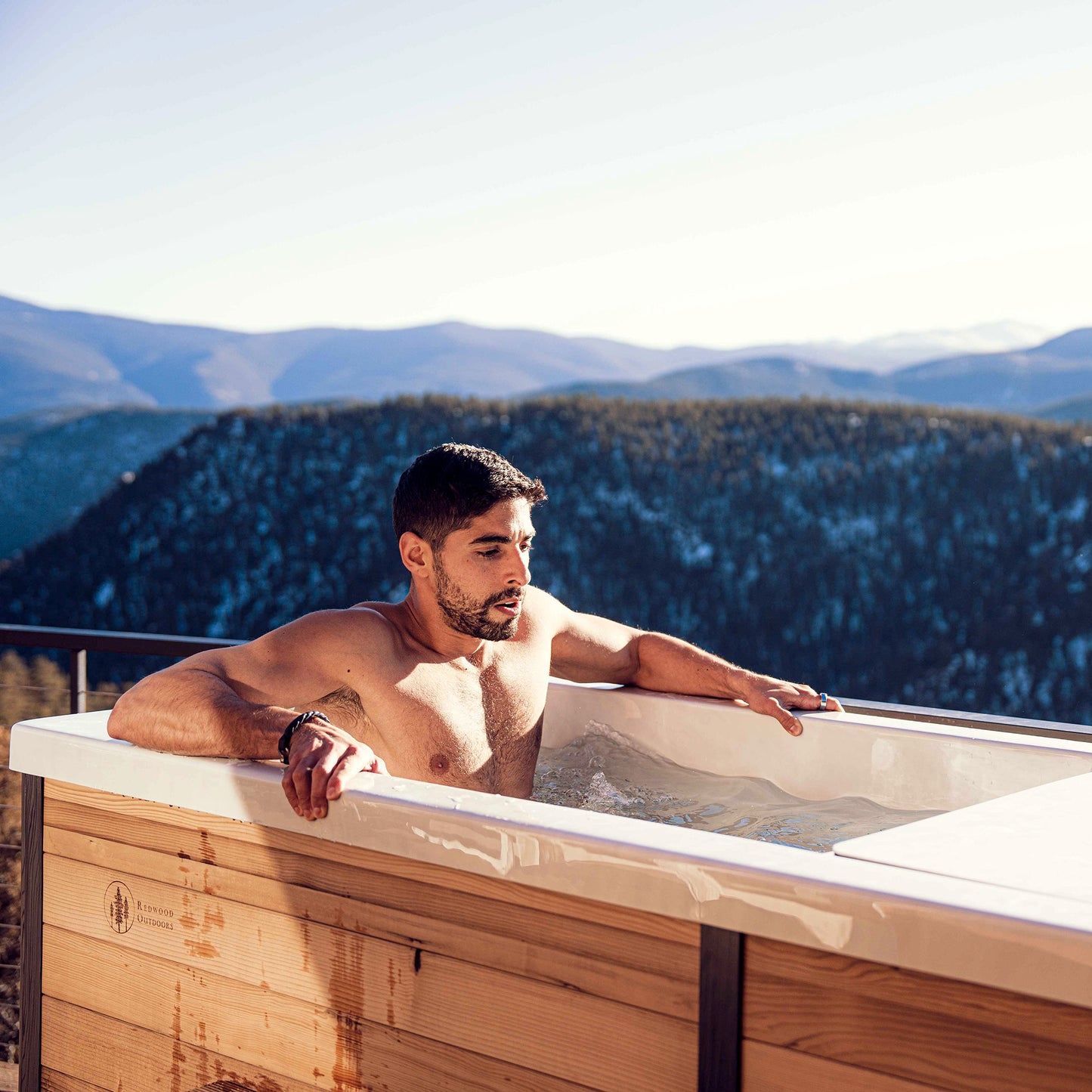 Redwood Outdoors Denali All-In_One Cold Plunge Tub made of heat treated wood exterior lifestyle view of a person in the cold plunge with water outdoors