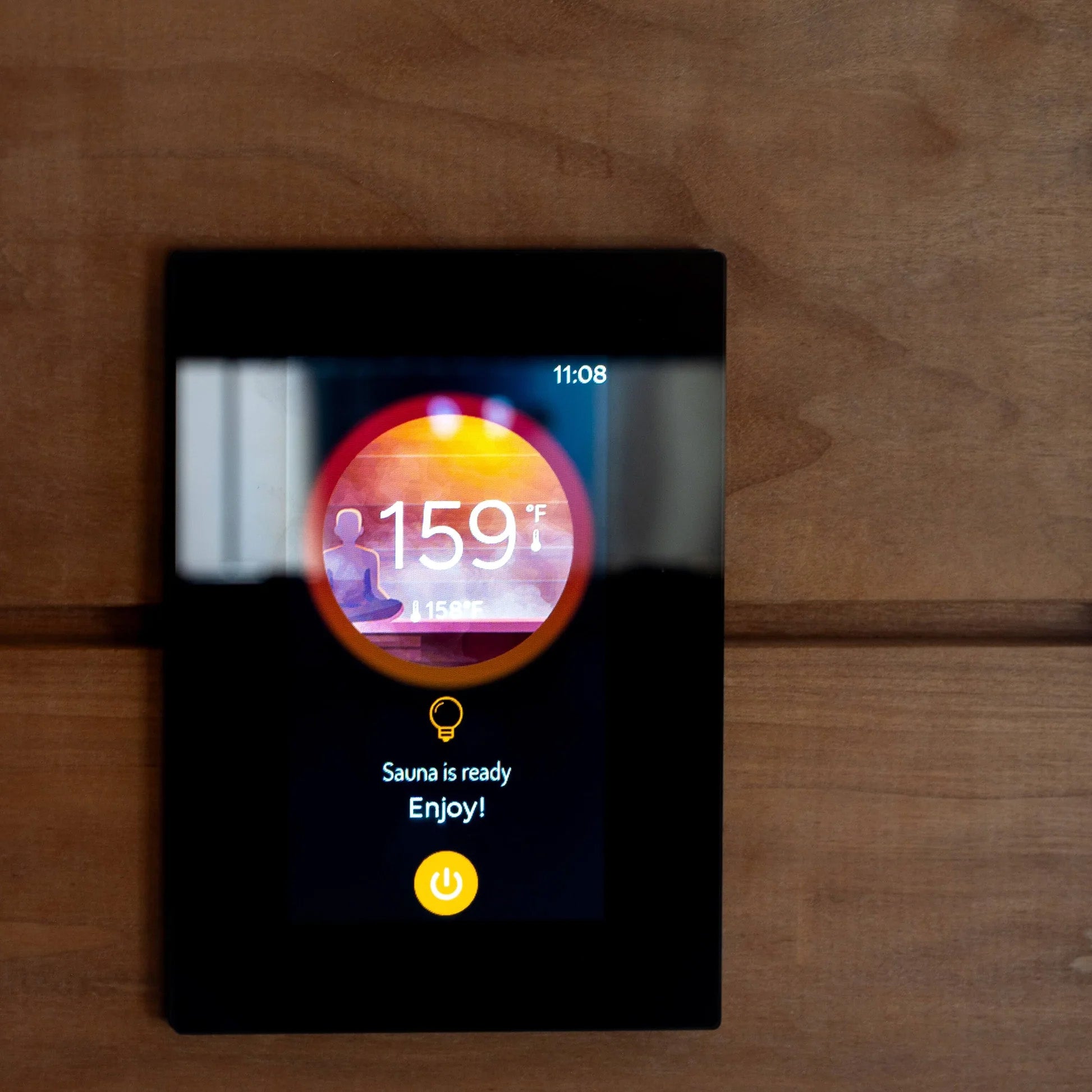 Harvia Fenix WiFi heater controller shown installed in a sauna with the electronic display on.