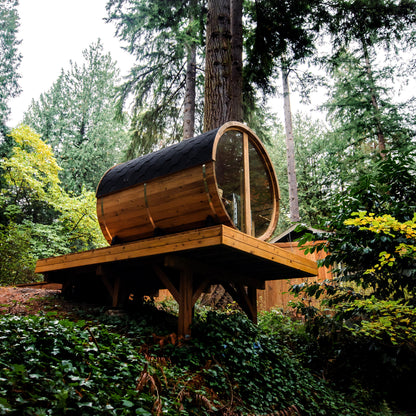Redwood Outdoors Horizon 6 person outdoor sauna with porch rear view of the sauna on a deck overlooking an outdoor space in the daylight.  