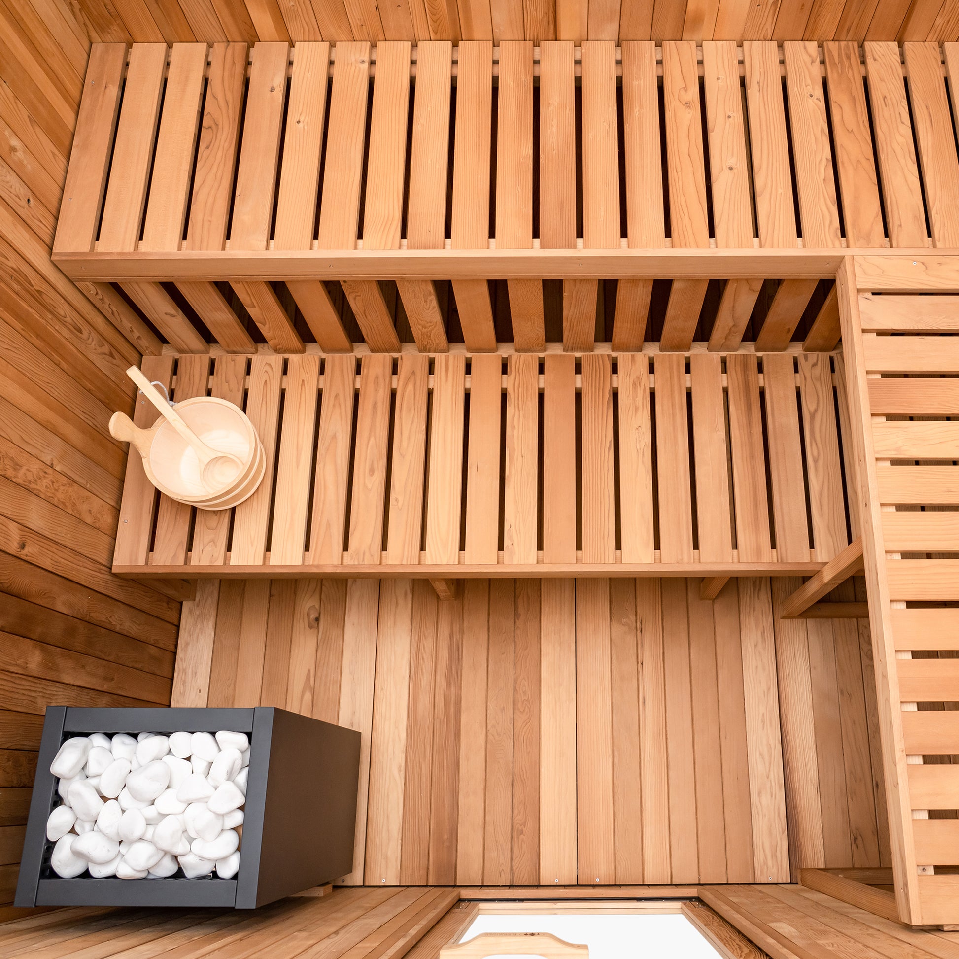 Redwood Outdoors Noctra 8 person sauna, made of hemlock wood stained black with a glass door view from the top of the sauna. 