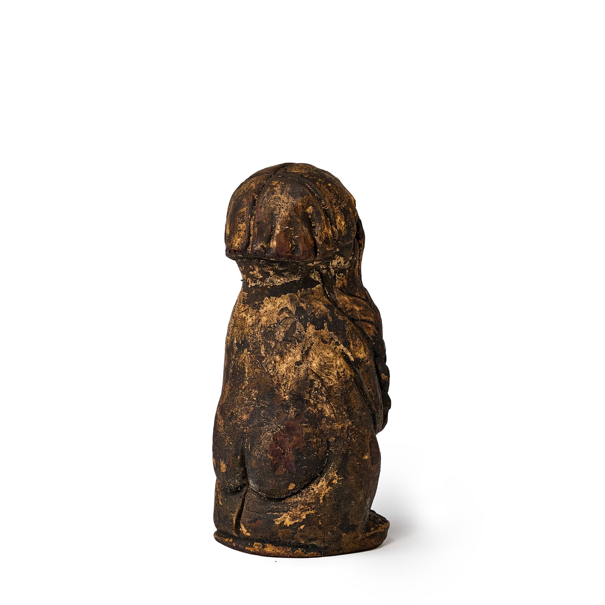 Small figure of an elf covered in pine tar back view