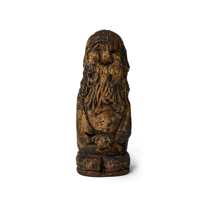 Small figure of an elf covered in pine tar front view