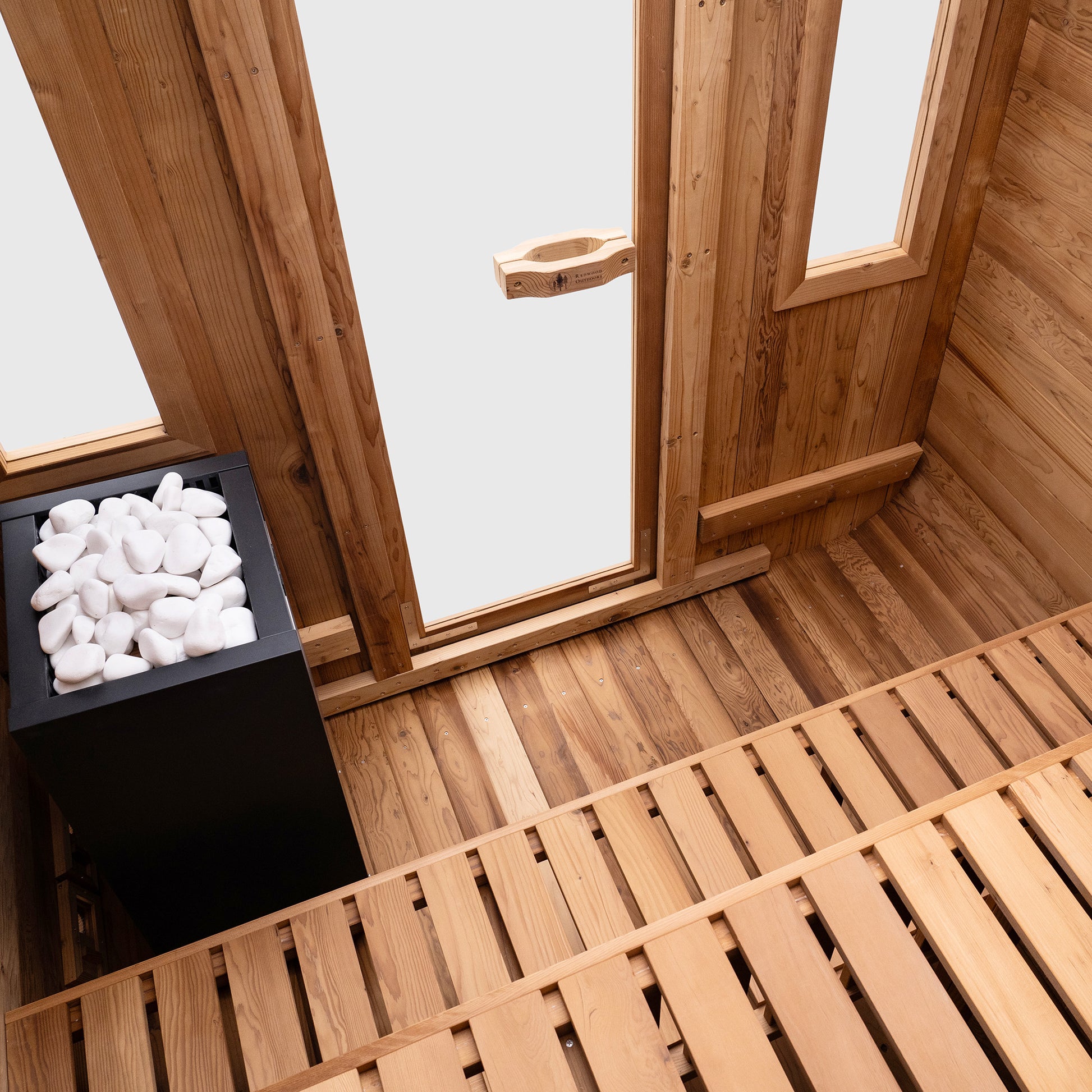 Redwood Outdoors Summit 6 person outdoor sauna, made of hemlock wood with a glass door and two large windows, interior rear view