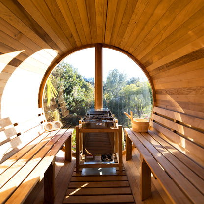Redwood Outdoors Vista 6 person outdoor sauna, made of hemlock wood with a large rear window, view from inside the sauna with two benches on both sides and a heater at the rear on the sauna.