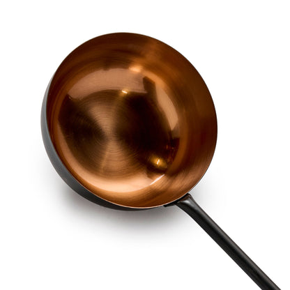Black and copper ladle close up view